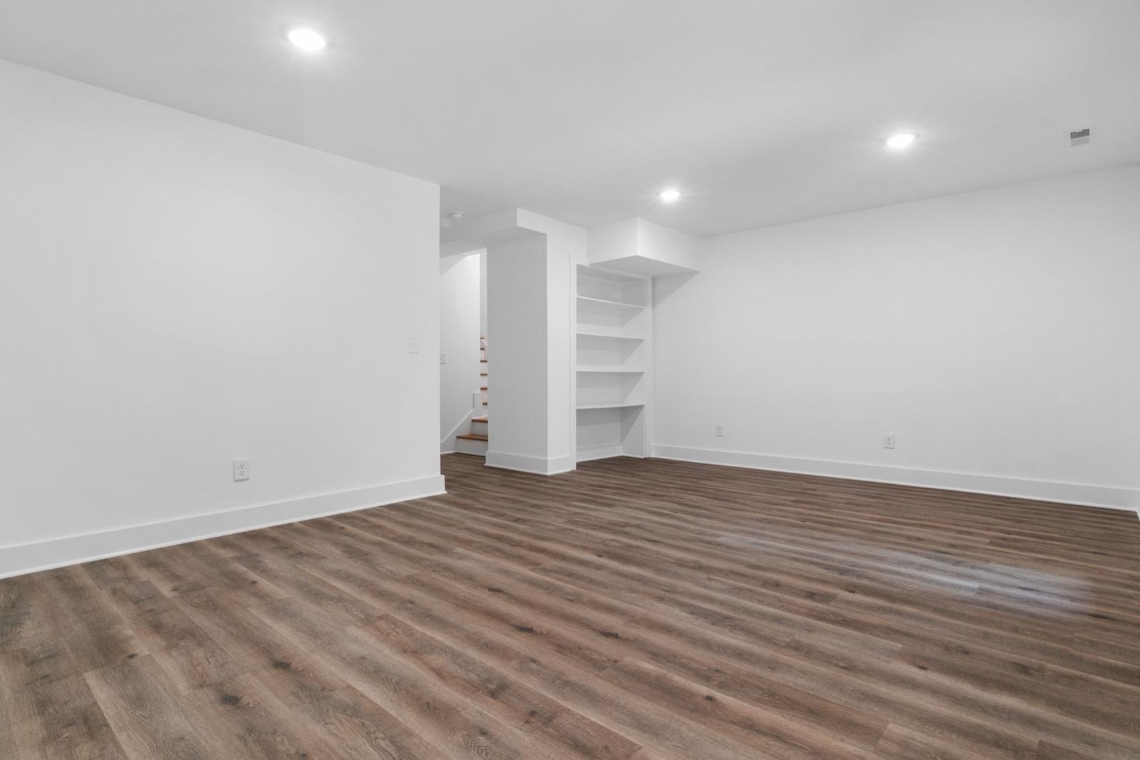 Finished basement with luxury vinyl plank flooring and built-in niches — AMV Construction, Charlotte NC
