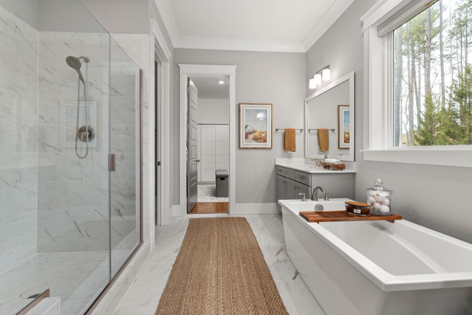 Primary bath with a marble-tile shower and freestanding soaking tub — AMV Construction, Charlotte NC