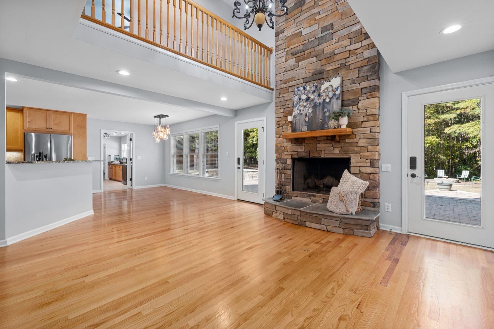 Great room with a floor-to-ceiling stone fireplace and hardwood floors — AMV Construction, Charlotte NC