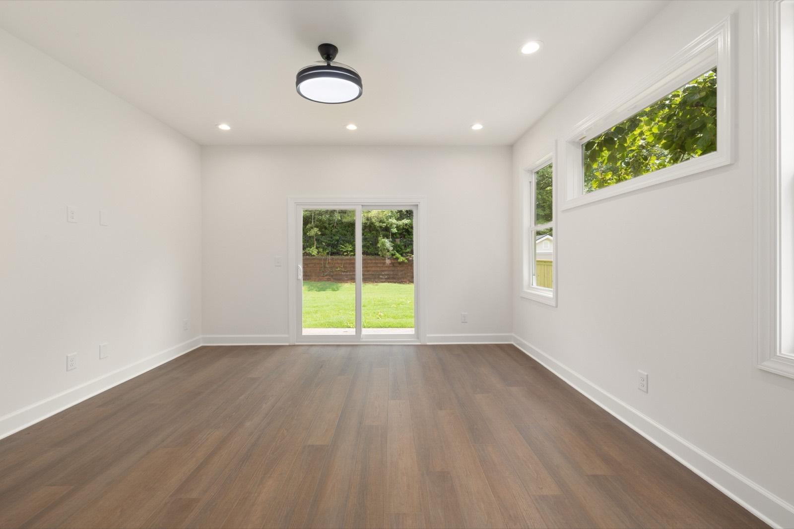 Converted space with luxury vinyl plank flooring and a sliding patio door — AMV Construction, Charlotte NC