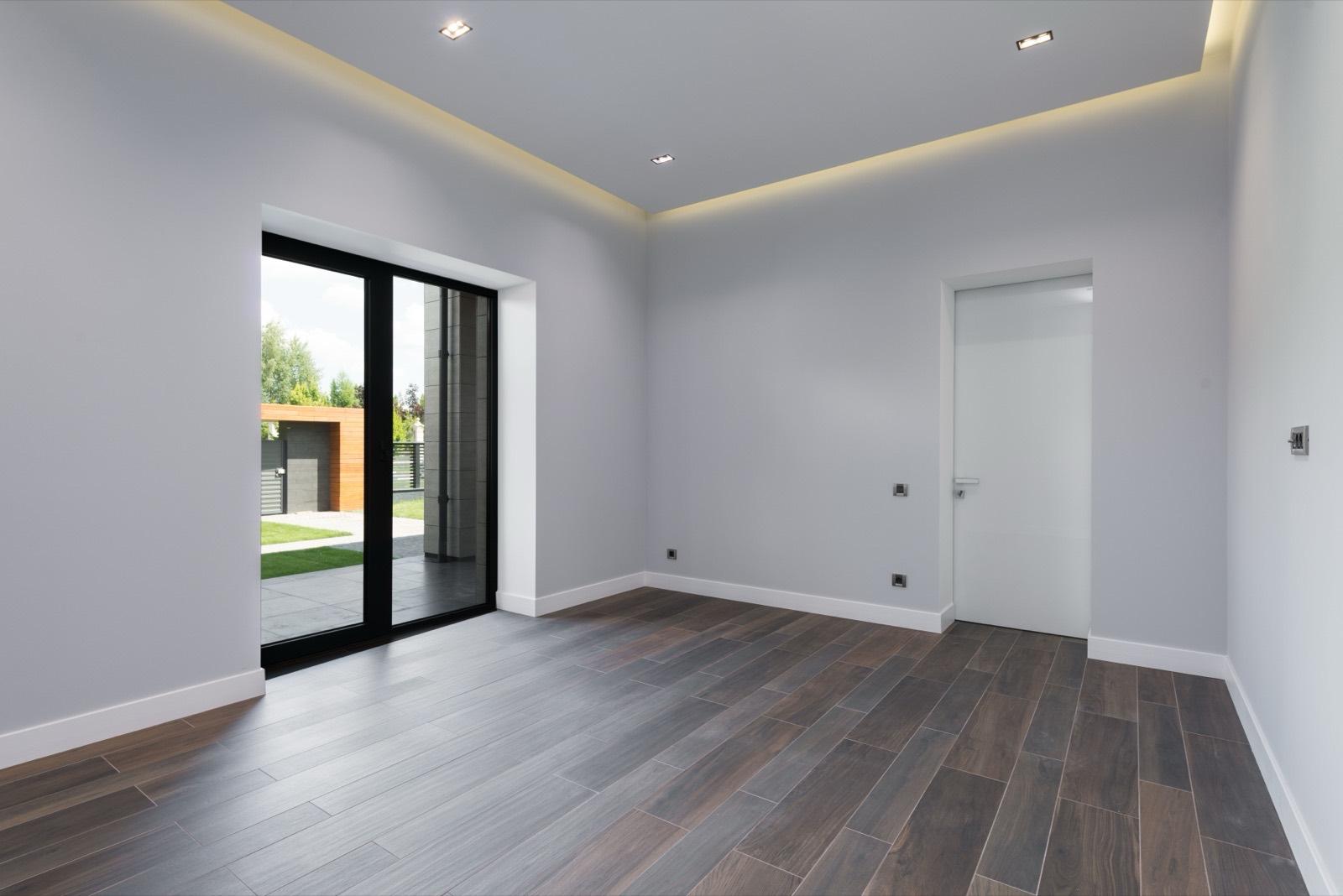 Freshly finished room with dark wood plank flooring and new sliding glass doors — AMV Construction, Charlotte NC