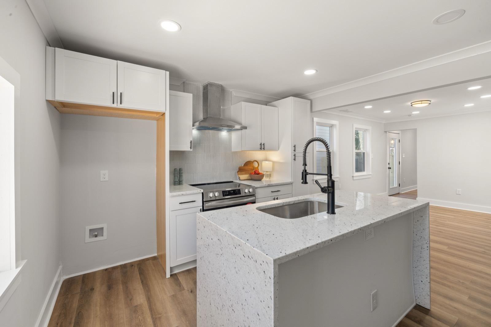 Compact kitchen with white cabinets and luxury vinyl plank flooring — AMV Construction, Charlotte NC