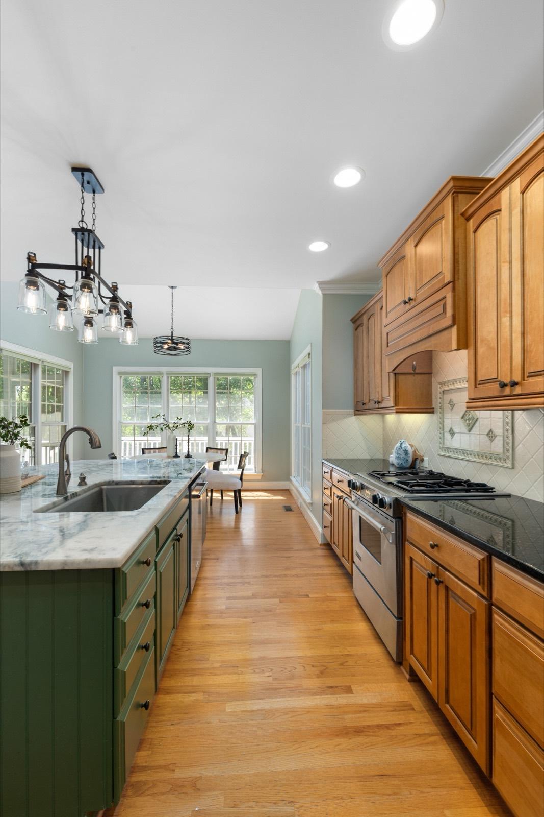 Kitchen with a green painted island and natural oak cabinetry — AMV Construction, Charlotte NC