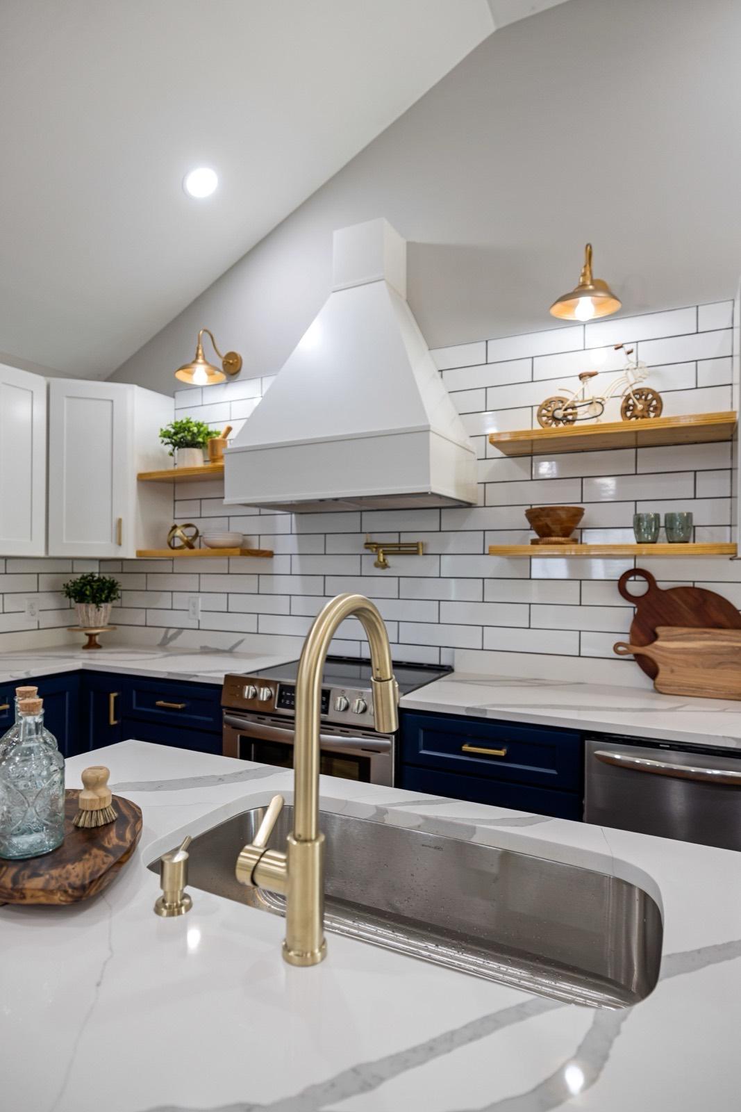 Kitchen with navy base cabinets, a white plaster hood, and subway tile — AMV Construction, Charlotte NC