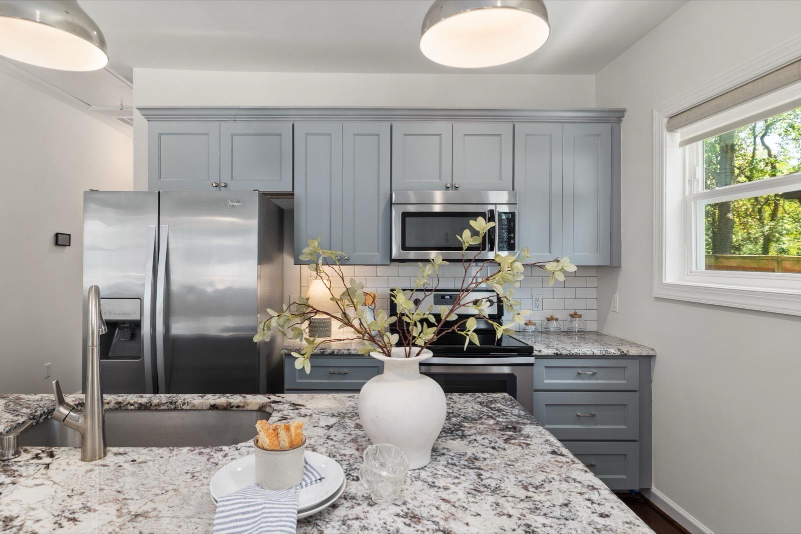 Kitchen with blue-gray cabinets and granite countertops — AMV Construction, Charlotte NC