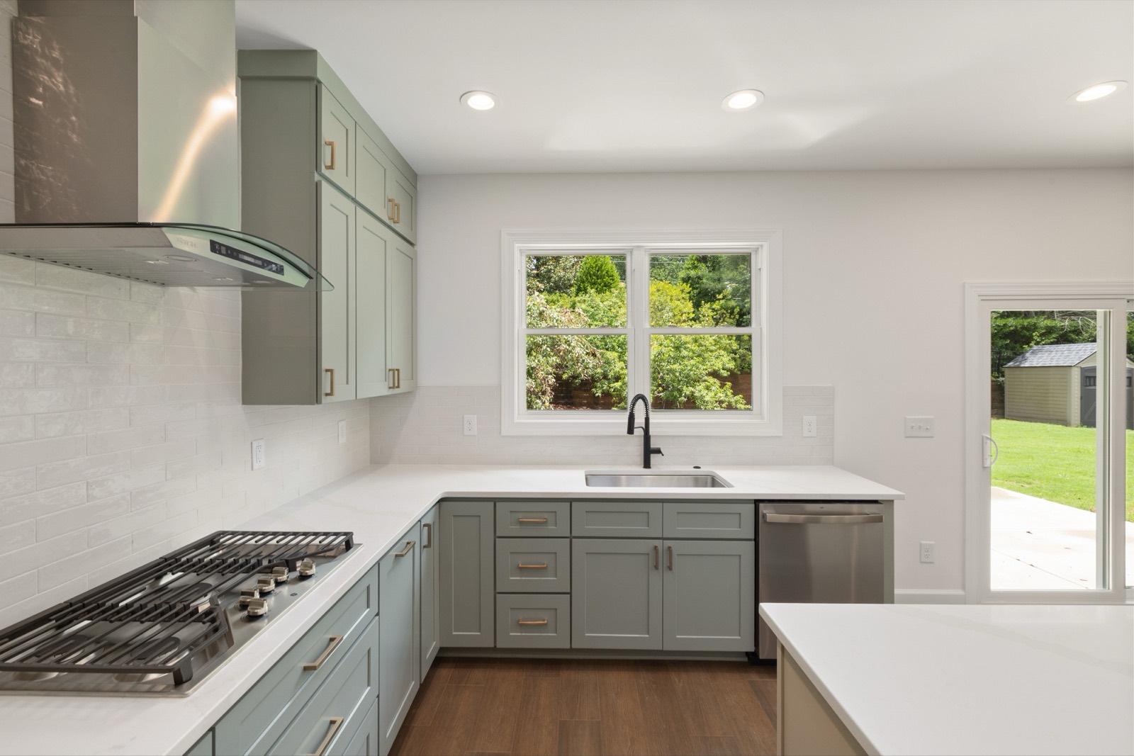 Sage cabinet kitchen with a window over the sink — AMV Construction, Charlotte NC