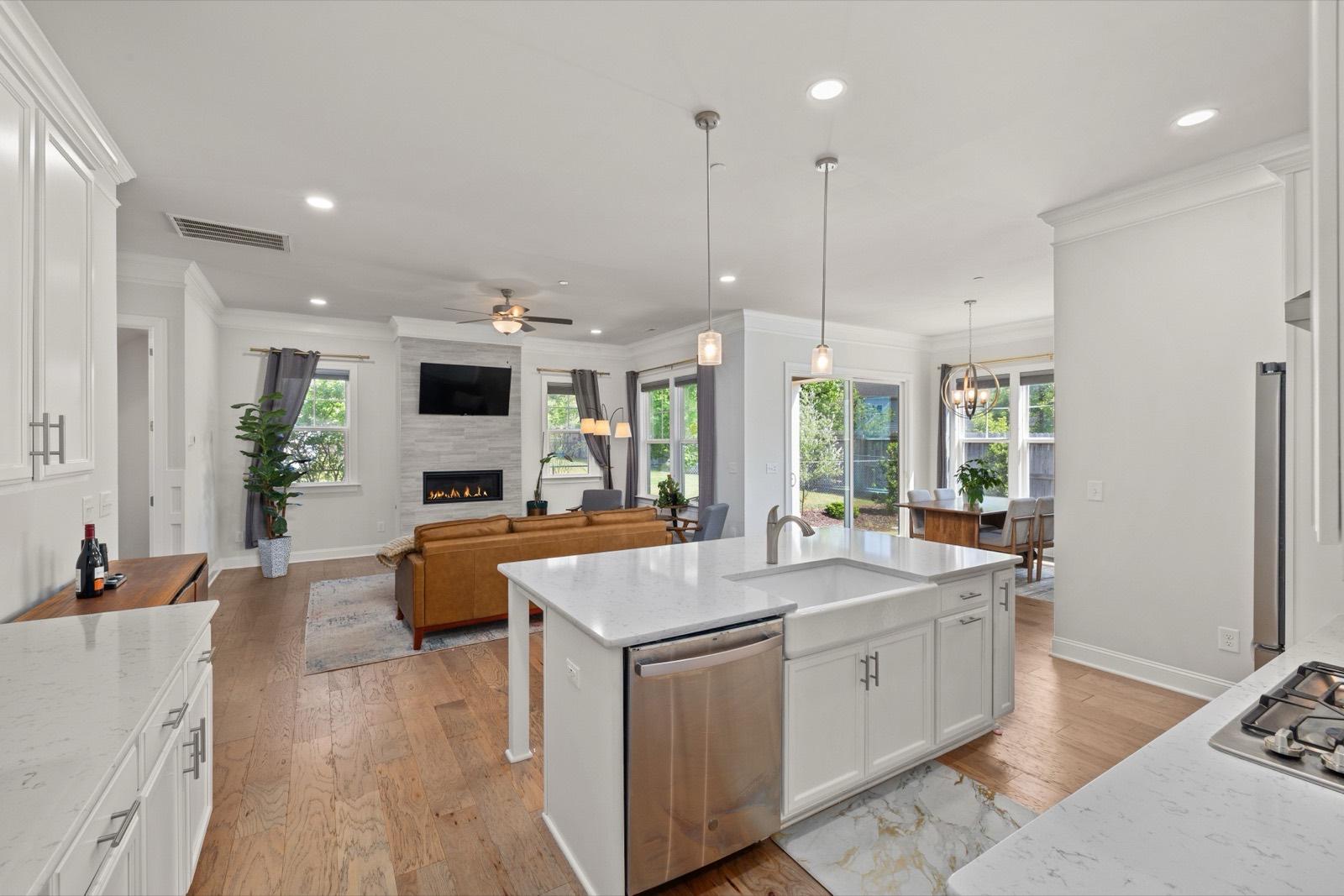 White kitchen open to the living room over wide-plank floors — AMV Construction, Charlotte NC
