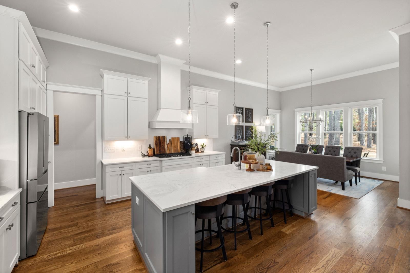 Kitchen with a gray island opening onto the dining room — AMV Construction, Charlotte NC
