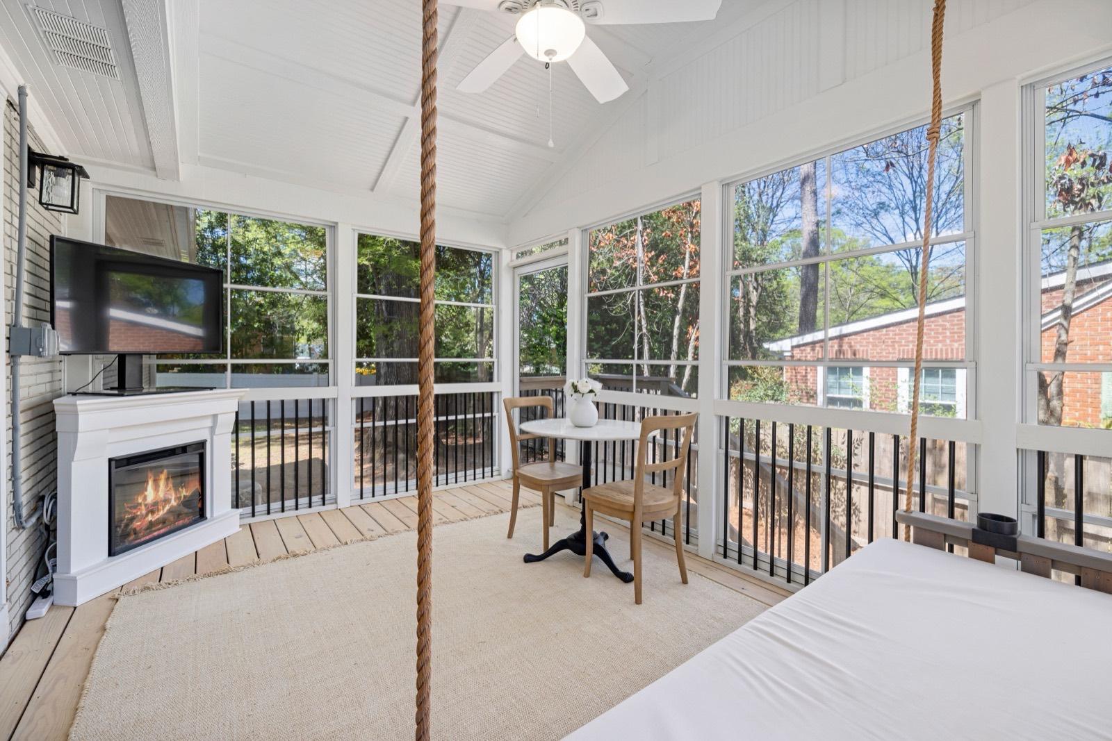 Screened porch with a gas fireplace and a hanging bed swing — AMV Construction, Charlotte NC