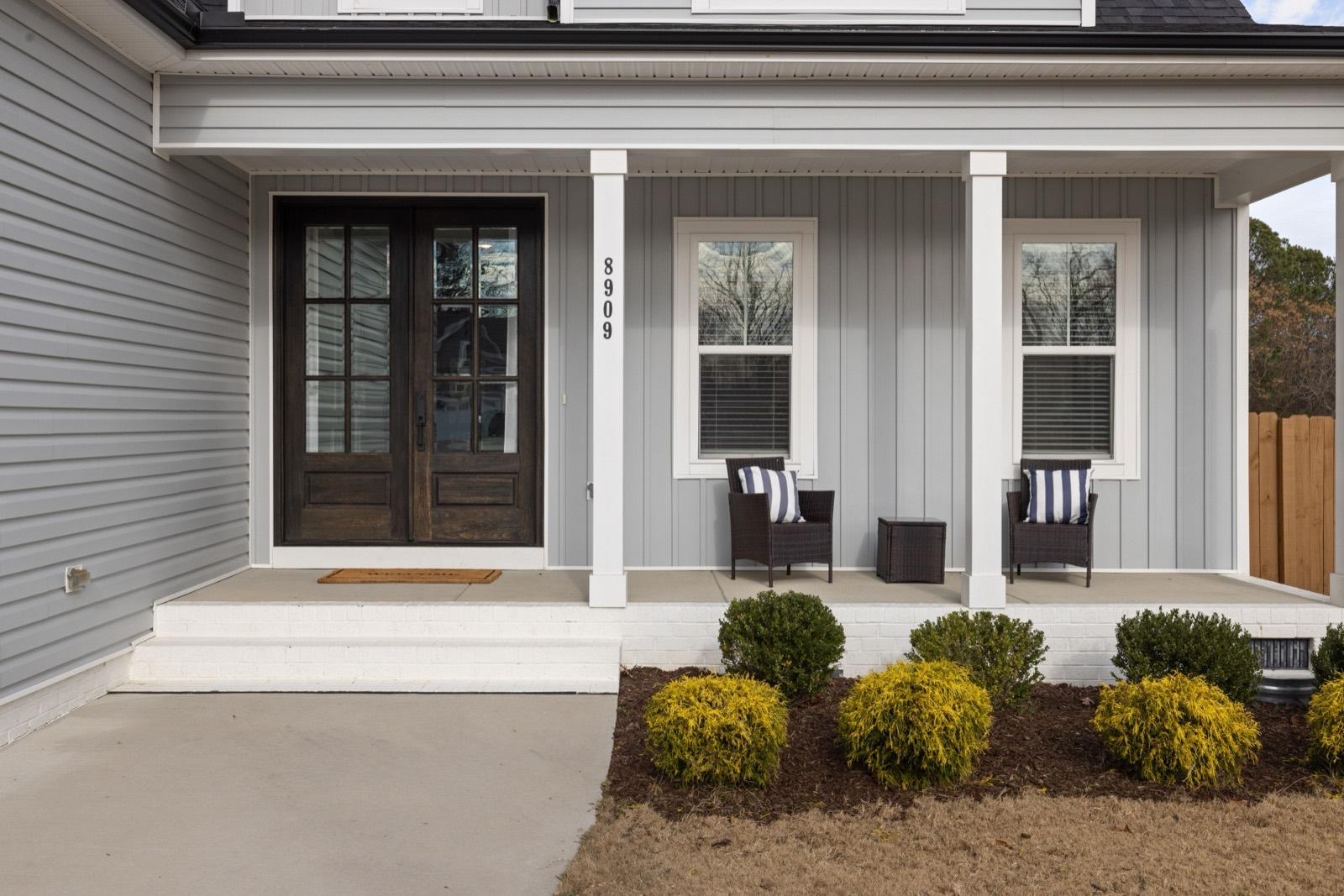 Front porch with painted columns and a wood-and-glass entry door — AMV Construction, Charlotte NC