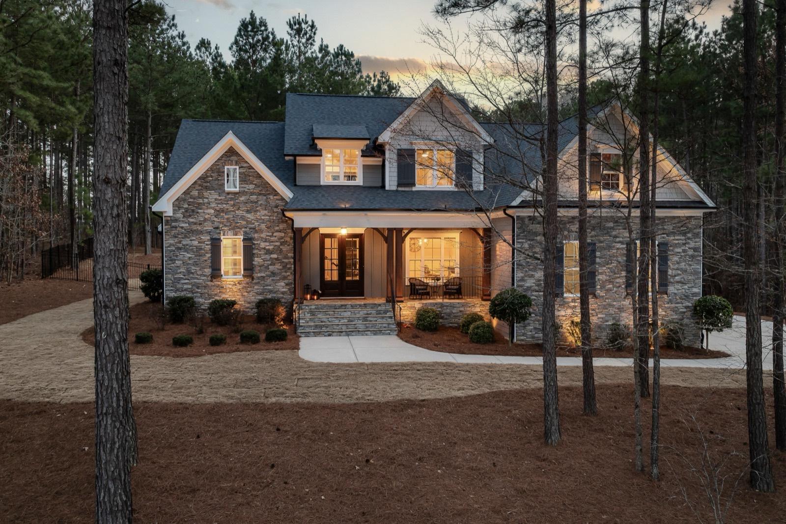 Stone-and-siding craftsman exterior photographed at dusk — AMV Construction, Charlotte NC