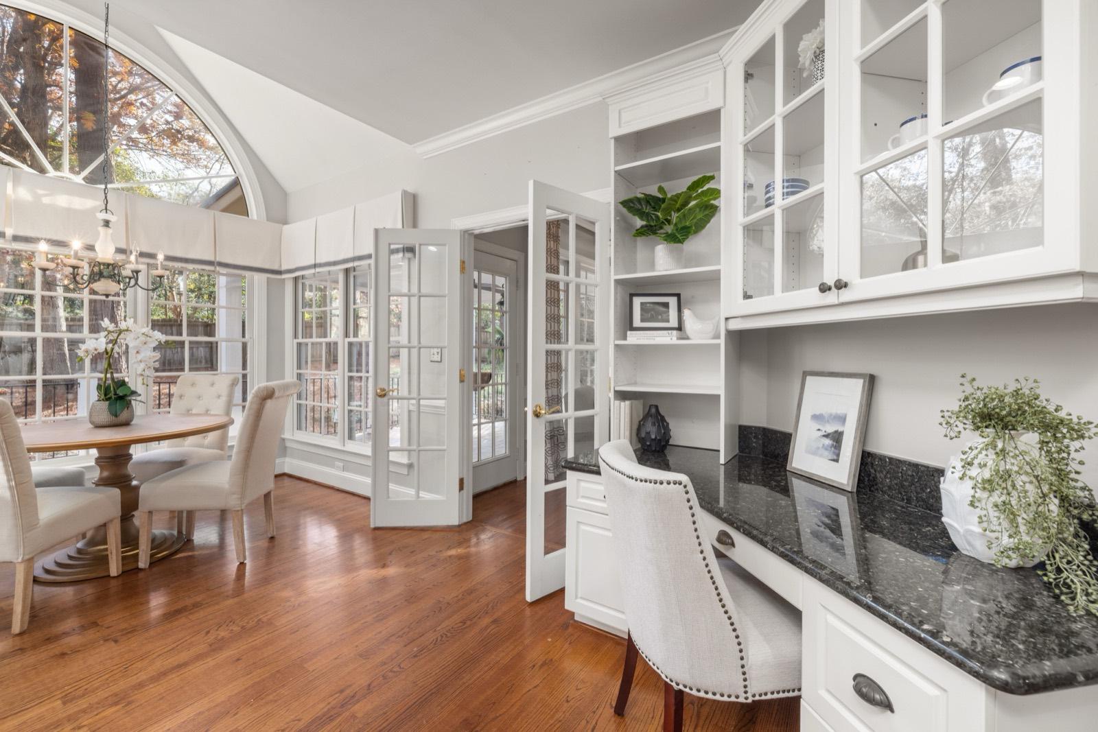 Sunroom with a built-in desk, custom cabinetry, and French doors — AMV Construction, Charlotte NC