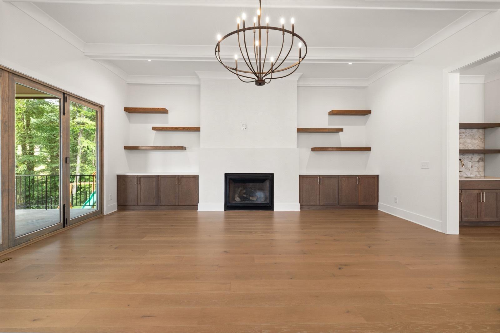 Great room with a coffered ceiling, floating shelves, and built-in cabinets — AMV Construction, Charlotte NC